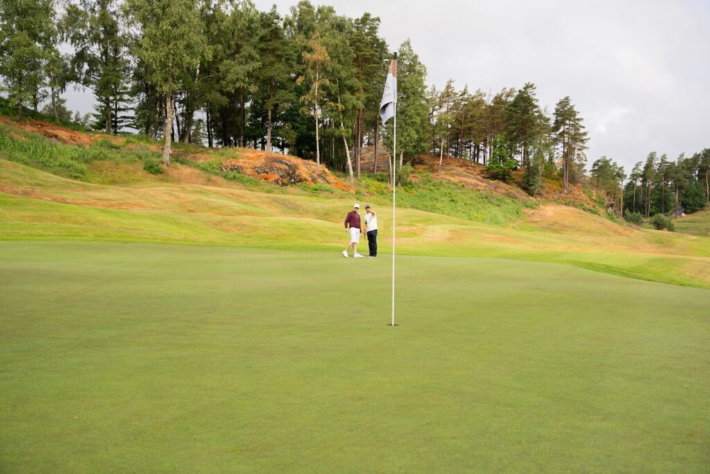 Two ESSIQ consultants standing on one of the fees at Hills Golf & Sports Club during the event ESSIQ-Golfen.